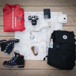 Travel Gear - black hiking backpack near white Fujifilm instax mini camera near black leather boots, red half-zip jacket, gray pocket watch on white map
