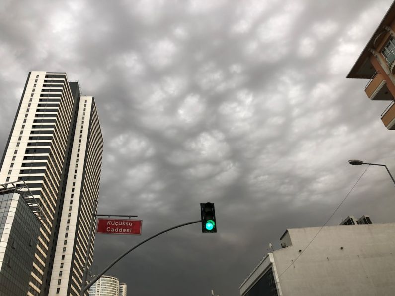 Nature Event - a green traffic light in front of tall buildings