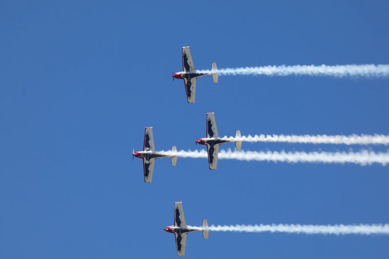 Local Event - four airplanes flying in formation in a blue sky