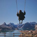 Traveling With Kids - a person swinging on a rope over a body of water