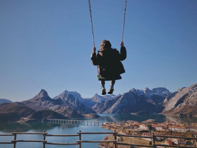 Traveling With Kids - a person swinging on a rope over a body of water