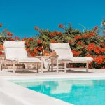 Private Spa - a pool with chairs and a table by it with flowers on the side