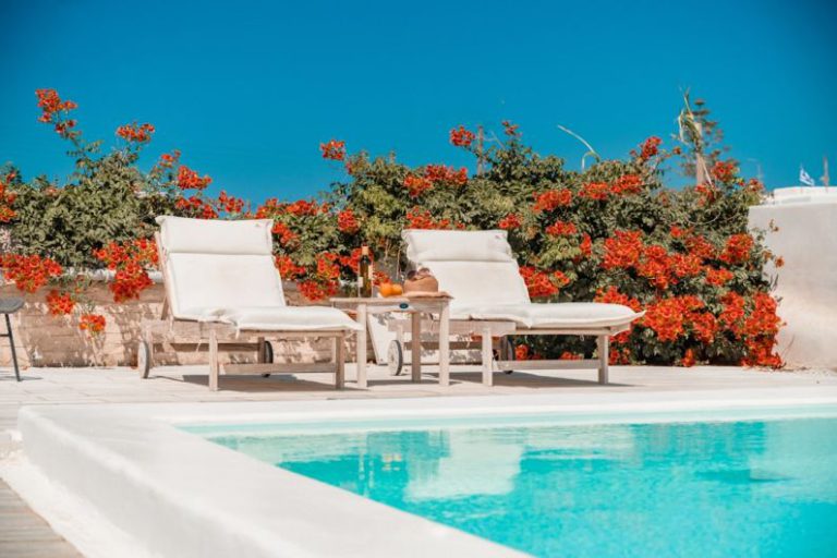 Private Spa - a pool with chairs and a table by it with flowers on the side