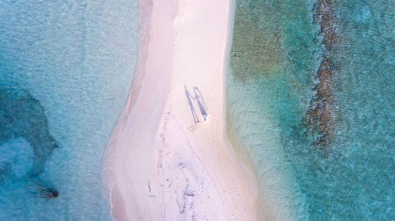 Luxury On Budget - aerial photography of couple standing between body of water