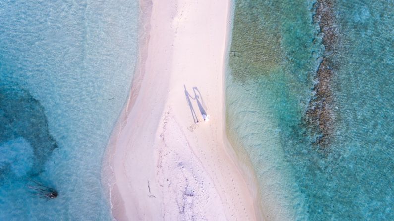 Luxury On Budget - aerial photography of couple standing between body of water