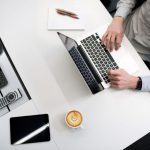 Budget Amenities - person using laptop on white wooden table