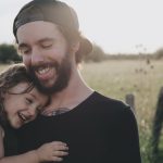 Budget Family B&B - man carrying daughter in black sleeveless top