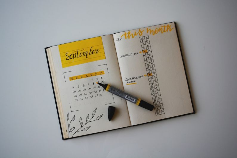 Charming Budget B&B - white planner with pen on top