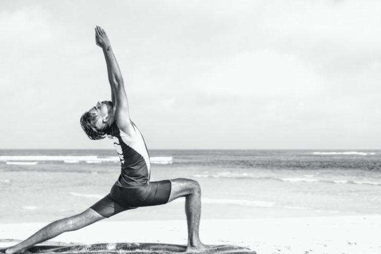 Stretch Budget - man stretching on seashore