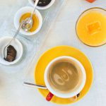 Gourmet Bed And Breakfast - white ceramic mug with coffee on yellow saucer