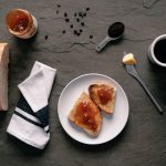 Breakfast Spread - white ceramic plate with stainless steel fork and bread knife