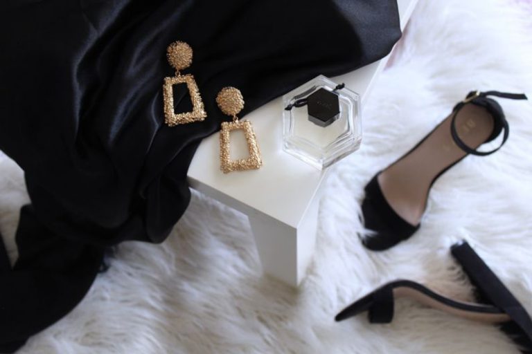 Luxury Bed And Breakfast - pair of gold-colored earrings on table and black ankle-strap pumps on area rug