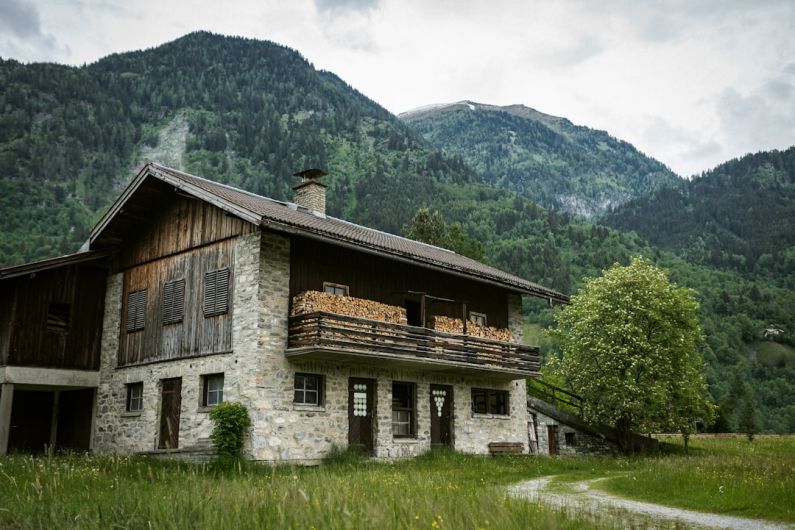 Nature Bed And Breakfast - brown wooden house on green grass field near green mountain during daytime