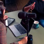 Host And Guest - a person with headphones on using a laptop