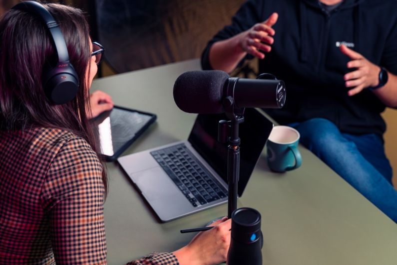 Host And Guest - a person with headphones on using a laptop