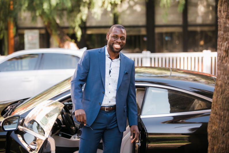 B&B Owner - man in blue suit standing beside black car