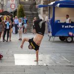 Summer B&B - man wearing black and yellow printed crew-neck t-shirt doing stunts a and people watching him