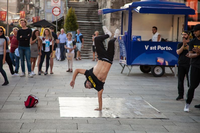 Summer B&B - man wearing black and yellow printed crew-neck t-shirt doing stunts a and people watching him