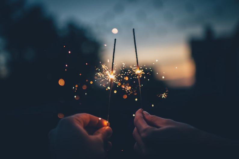New Year's Eve B&B - person holding fire cracker shallow focus photography