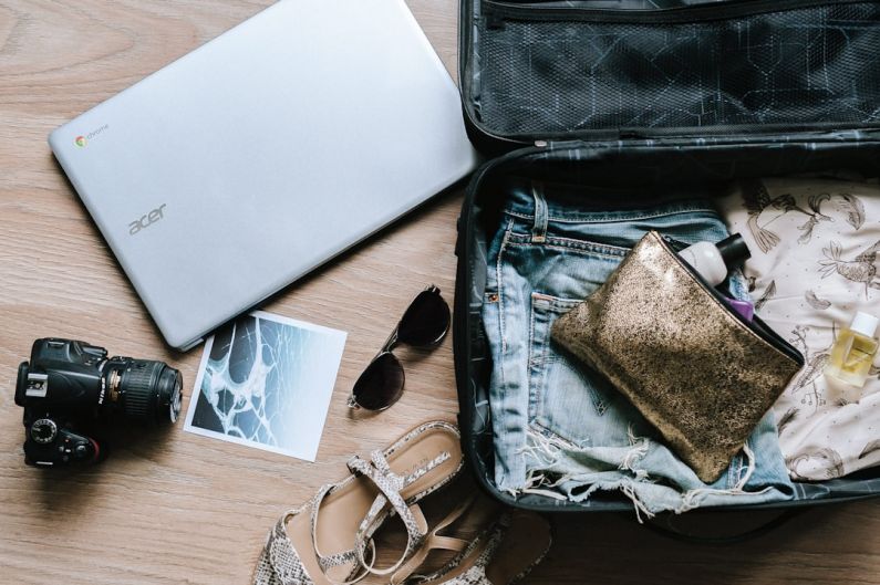 Packing Suitcase - black DSLR camera near sunglasses and bag